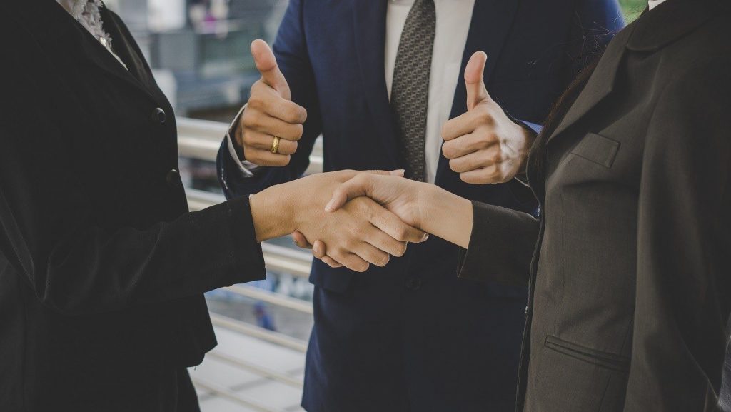 shaking hands and one person giving thumbs up